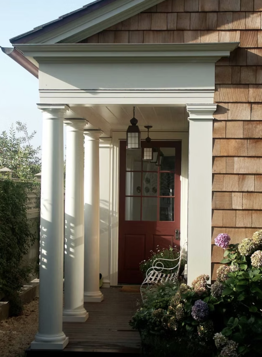 Classical portico entry with white columns and red door